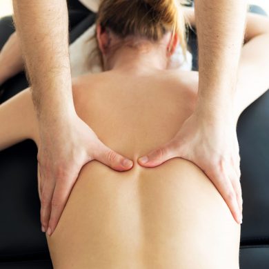 Shot of young physiotherapist doing a back treatment to the patient in a physiotherapy room. Rehabilitation, medical massage and manual therapy concept.